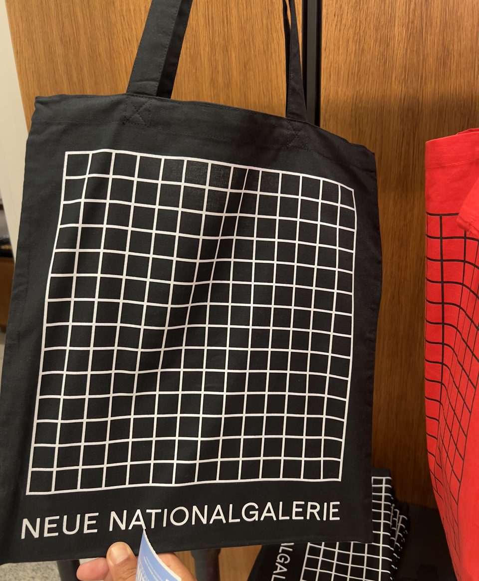Sacoșă neagră de pânză, imprimată cu o grilă albă de pătrate și textul Neue Nationalgalerie